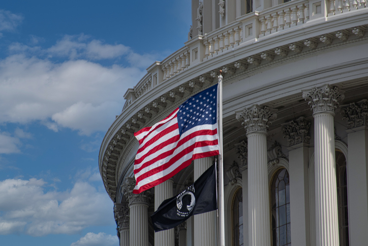 U.S. Capitol Building with American flag and POW/MIA flag flying below.