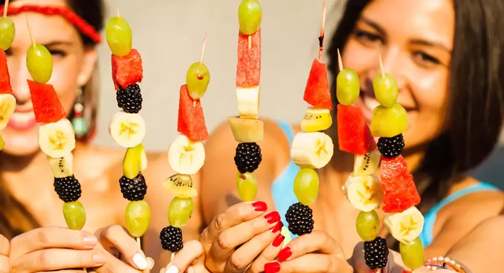 fruitbouquets.com deal hero girls eating fruit kabobs