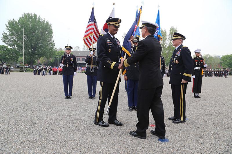 Army Gen. Vincent K. Brooks takes the U.S. Forces Korea colors from Navy Adm. Harry B. Harris, the commander of U.S. Pacific Command during a change of command ceremony at Yongsan Garrison, South Korea, in which Brooks took command of United Nations Command, Combined Force Command and U.S. Forces Korea, April 30, 2016. (Photo by Army Sgt. Russell Youmans)